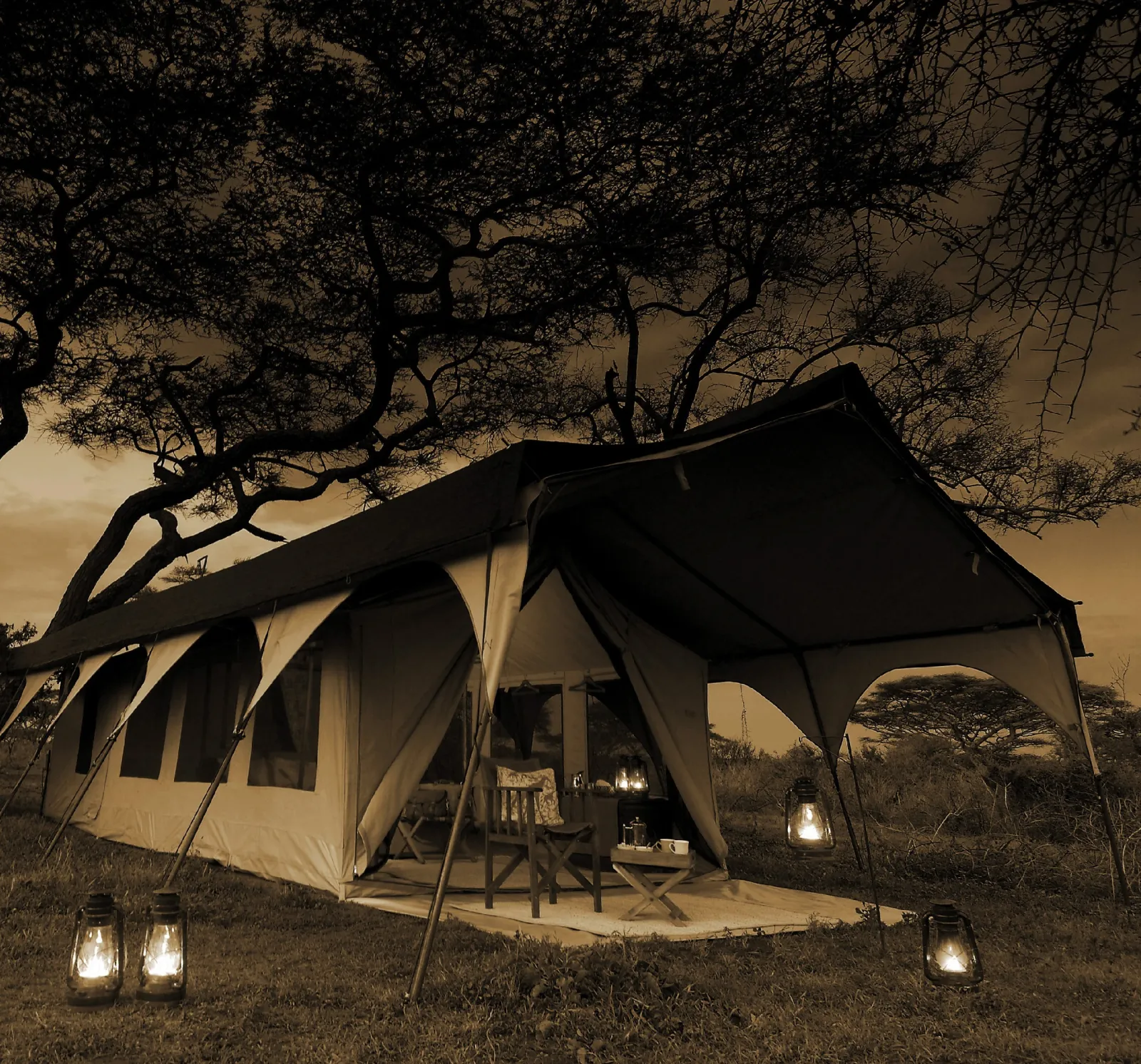 A tent lit by lanterns at night